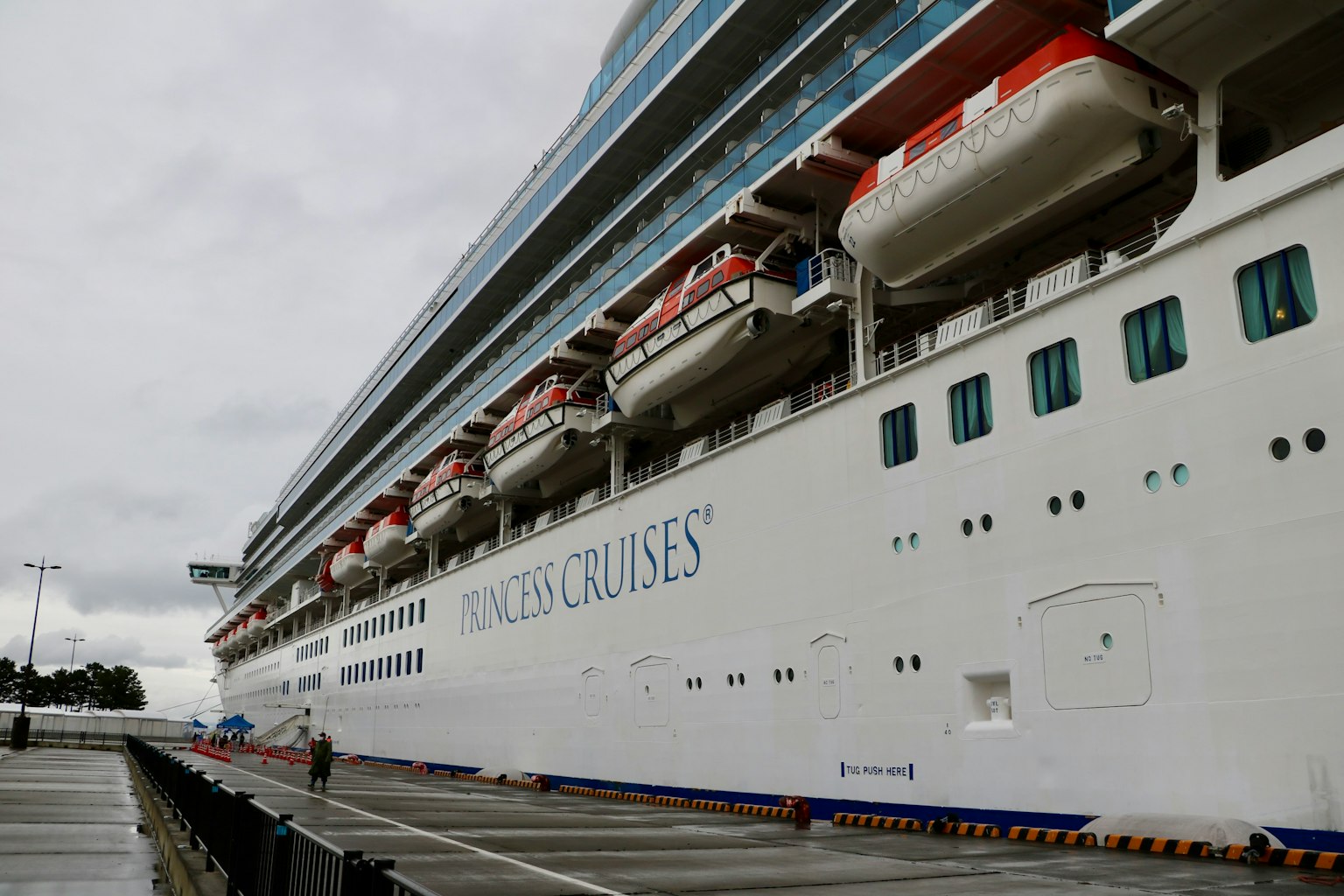 Side view of a large cruise ship with lifeboats