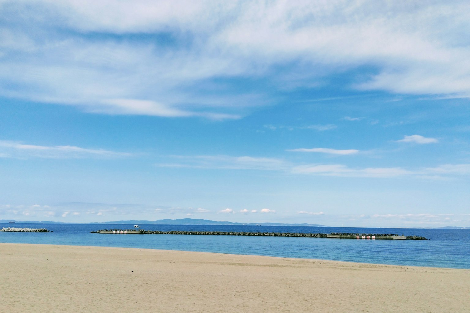 海灘景觀，藍天和海洋，沙灘和碼頭可見