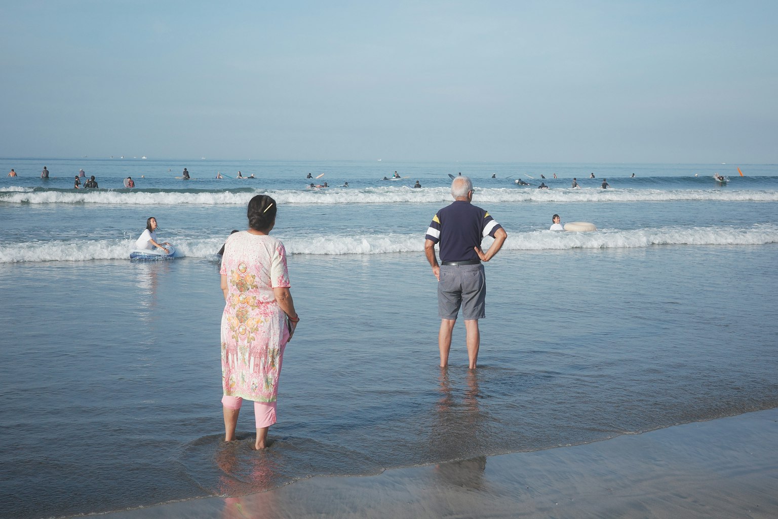 Couple standing at the beach looking at the ocean