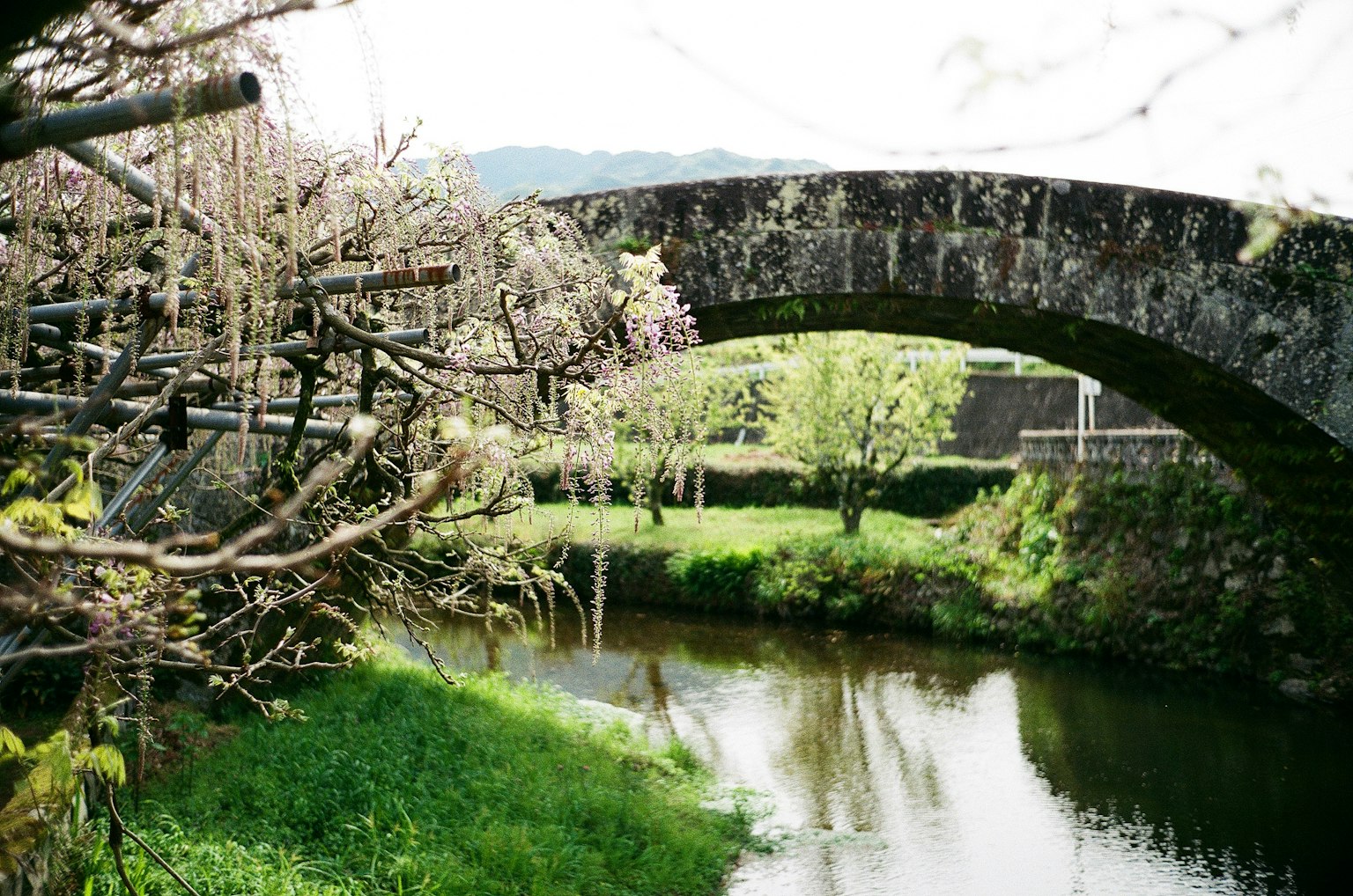 Malersicher Blick auf eine Steinbogenbrücke über einen ruhigen Fluss
