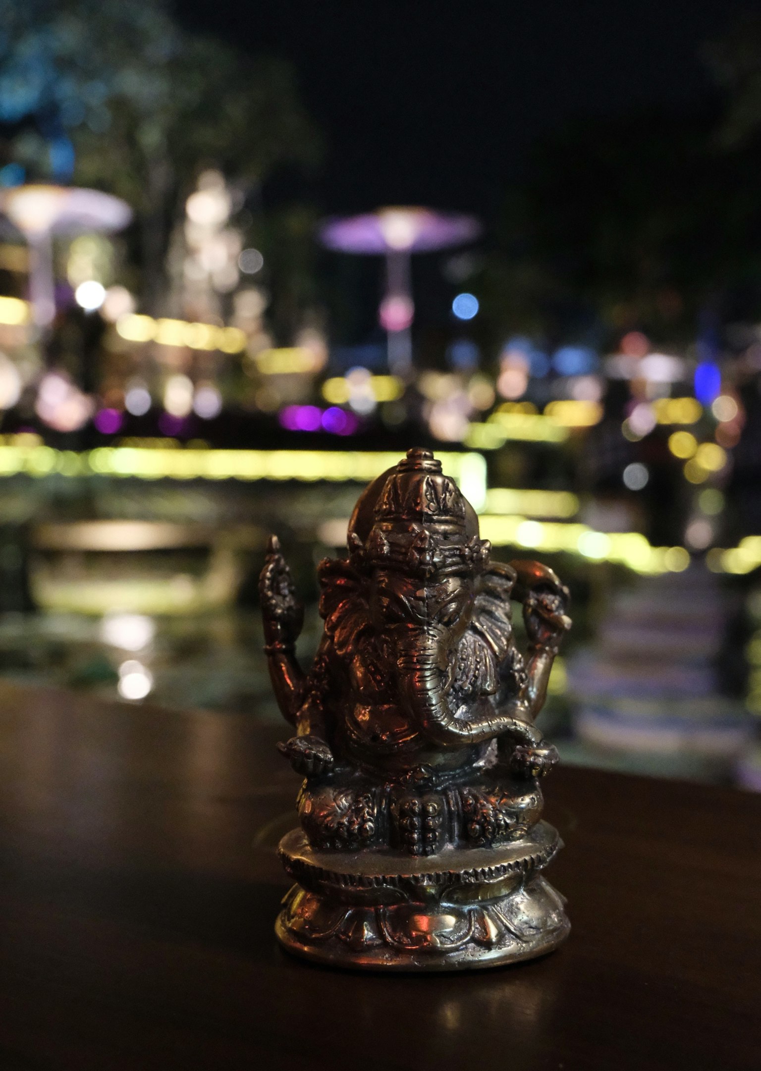 夜の背景に銀色のガネーシャ像が置かれている