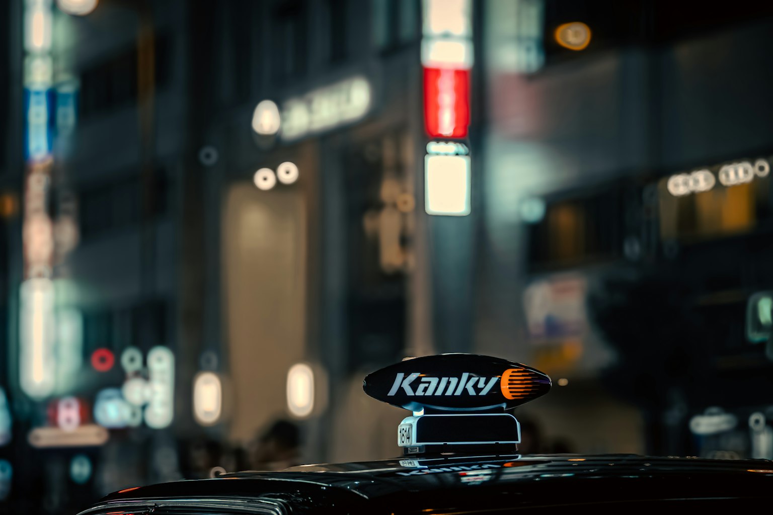 夜間城市環境中寫有Kanky的計程車標誌