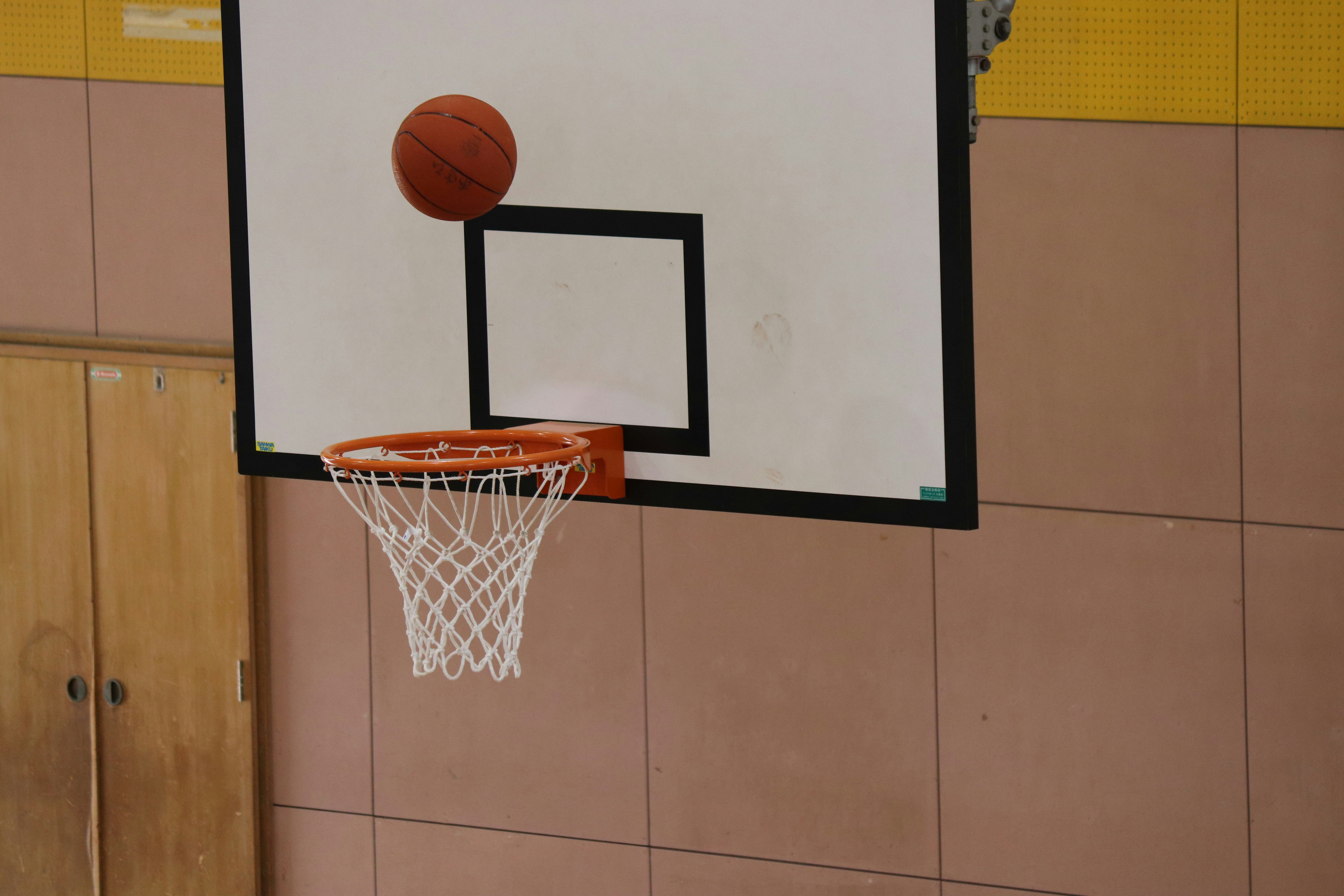gym basketball hoop with a ball near the rim