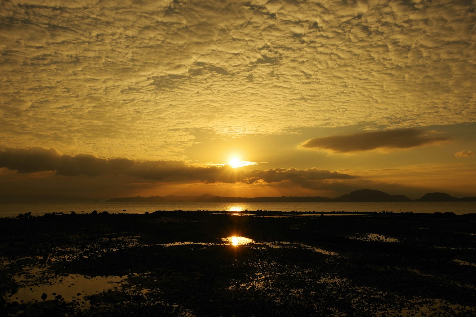 Beautiful sunset shining through clouds reflecting on the sea
