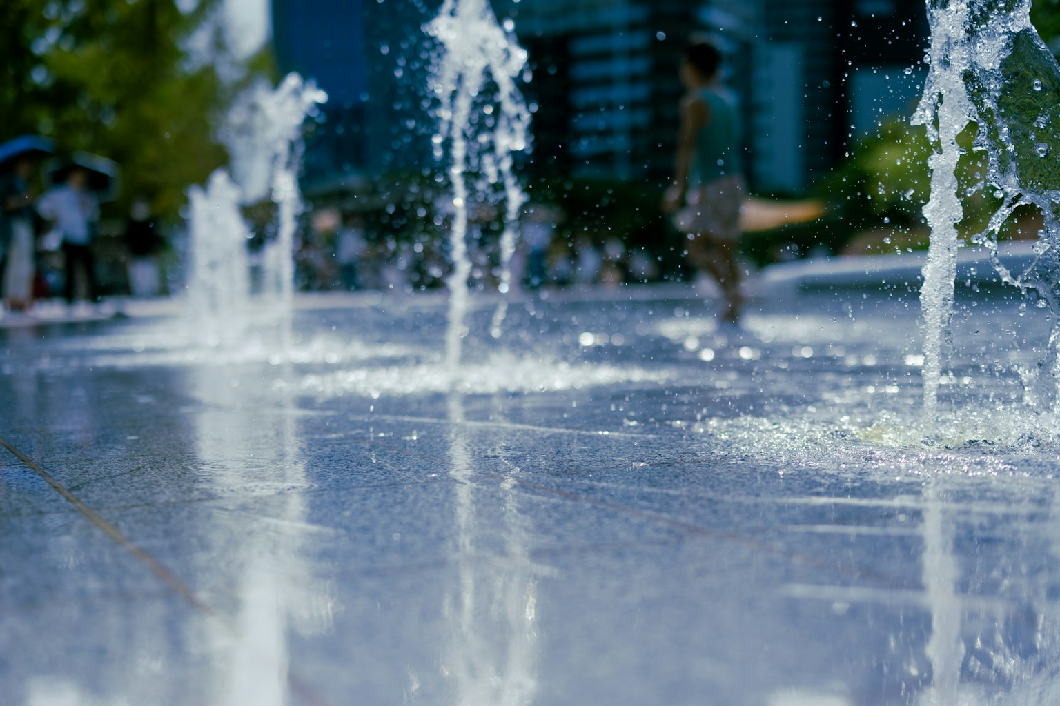 Szene eines Parks mit Brunnen, in dem Menschen Spaß haben