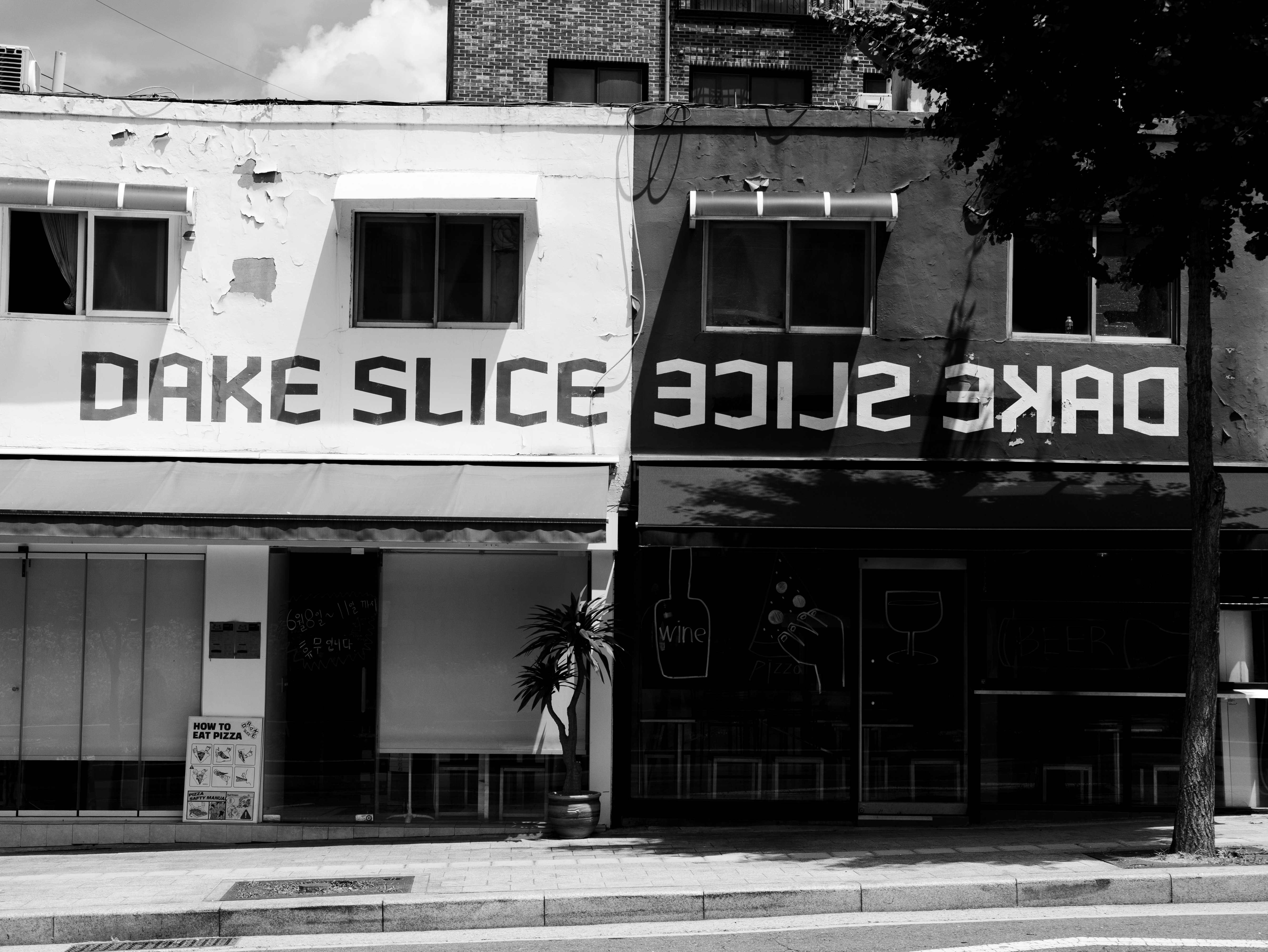 「DAKE SLICE」看板のある路地の飲食店外観