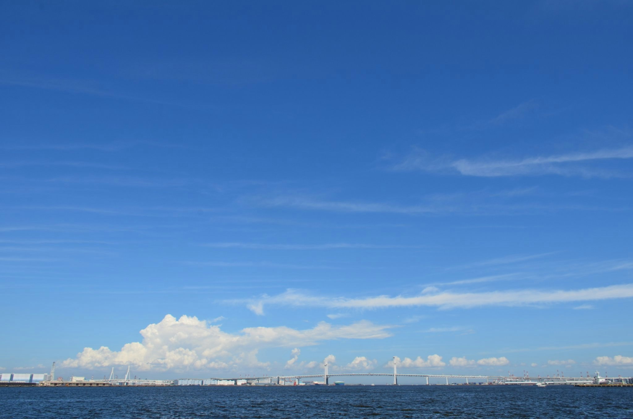 海面與遠處發電設施的海岸景觀