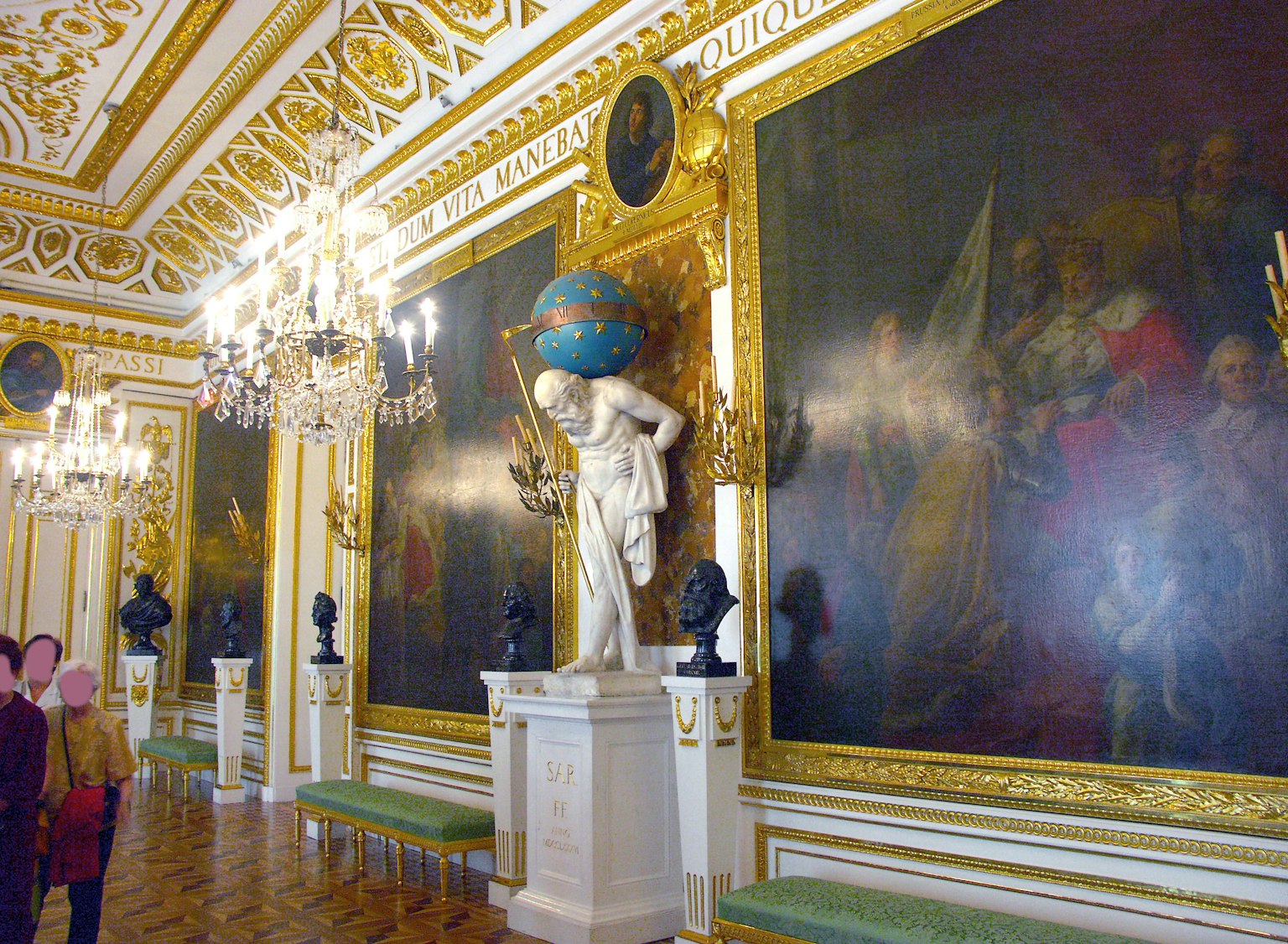 Stanza con una statua e grandi dipinti con decorazioni dorate ornate