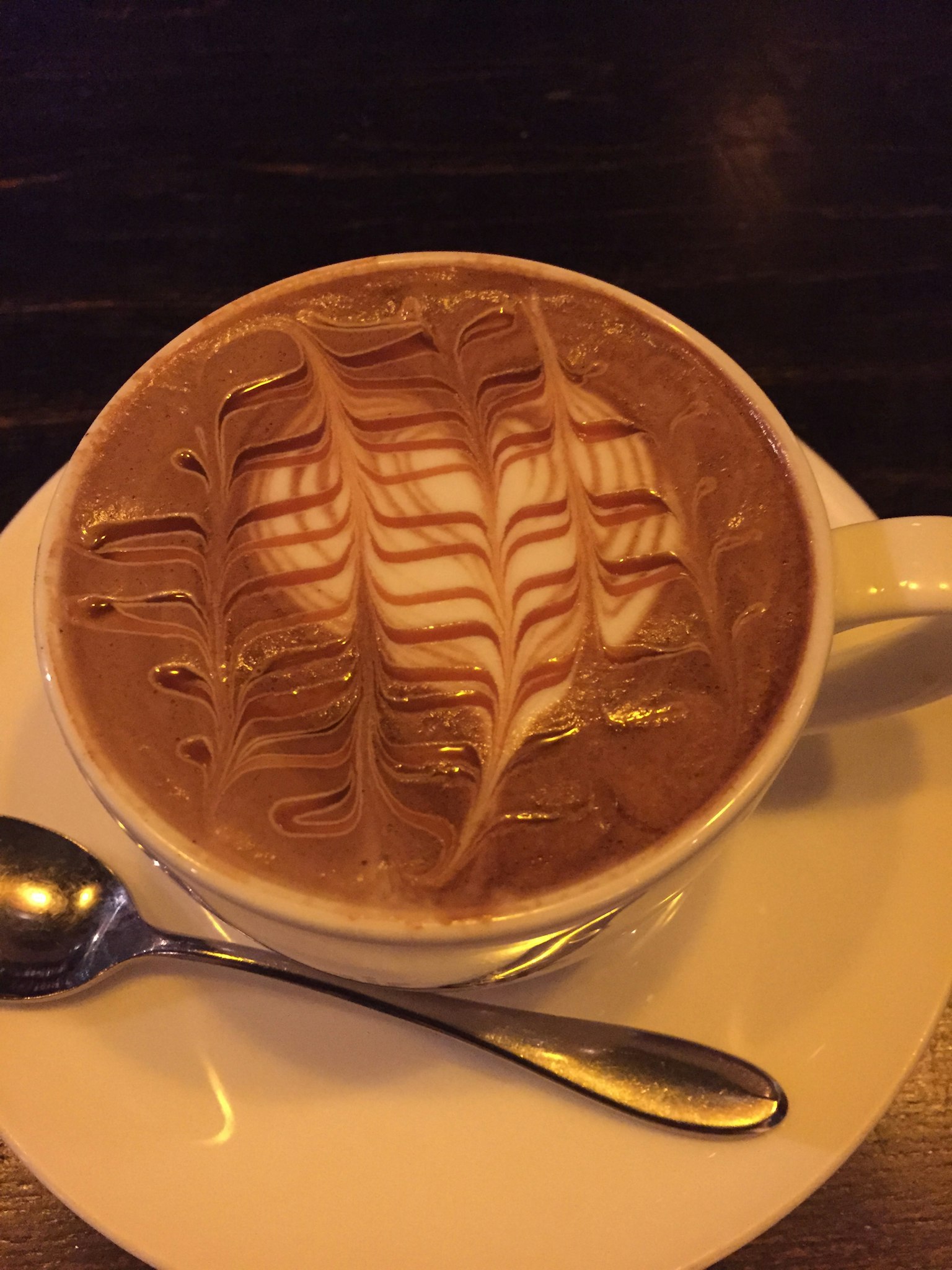 Eine Tasse Latte Art mit einem Löffel