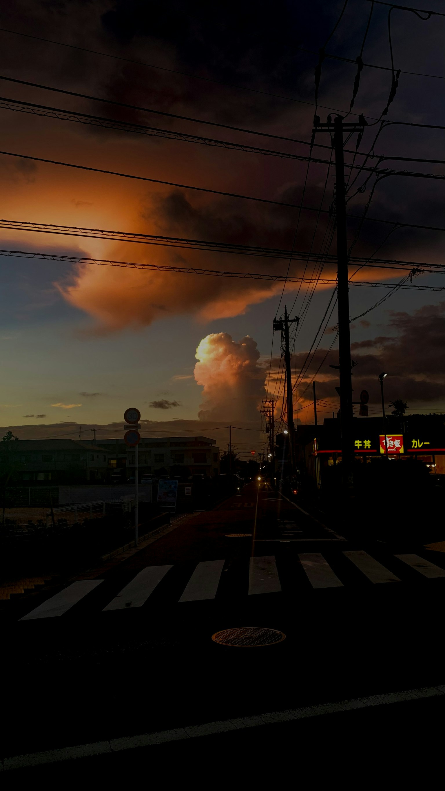 Un cielo al tramonto con nuvole e pali della luce