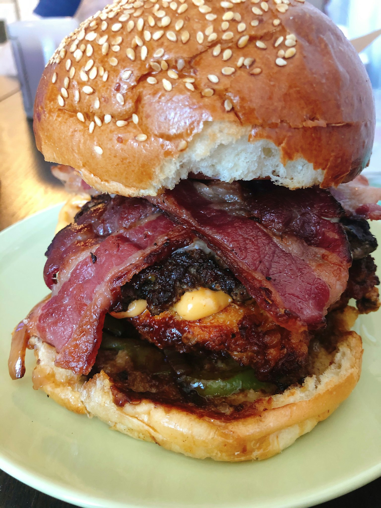 Gourmet bacon cheeseburger nestled in sesame seed bun