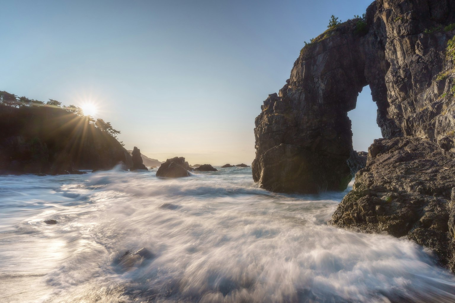 Hermoso paisaje de olas oceánicas rodeando un arco de roca