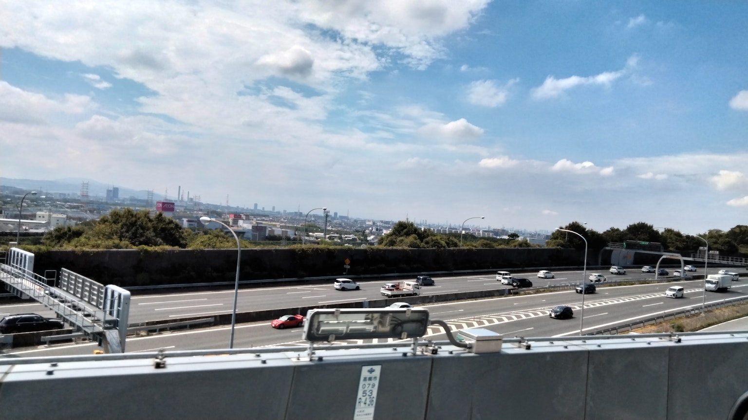 Pemandangan jalan raya dengan mobil yang melaju di bawah langit biru
