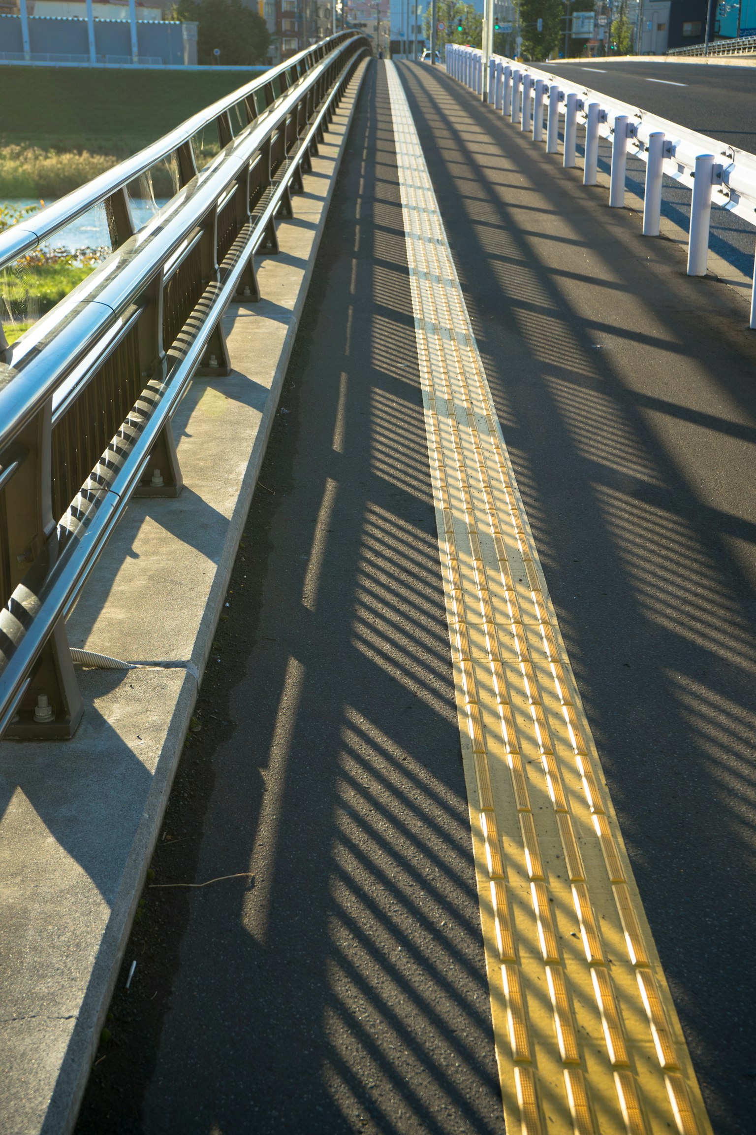 Acera en un puente con sombras distintivas y líneas amarillas