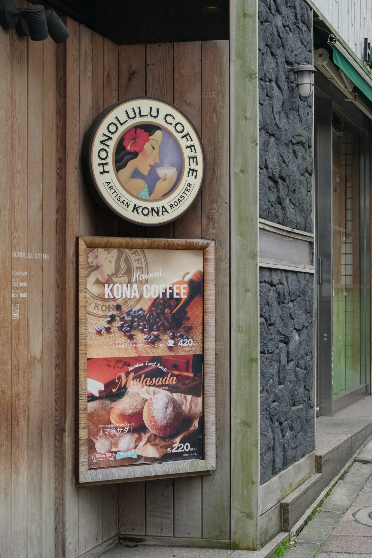 Esterno di un negozio con insegna Honolulu Coffee e pubblicità del caffè Kona