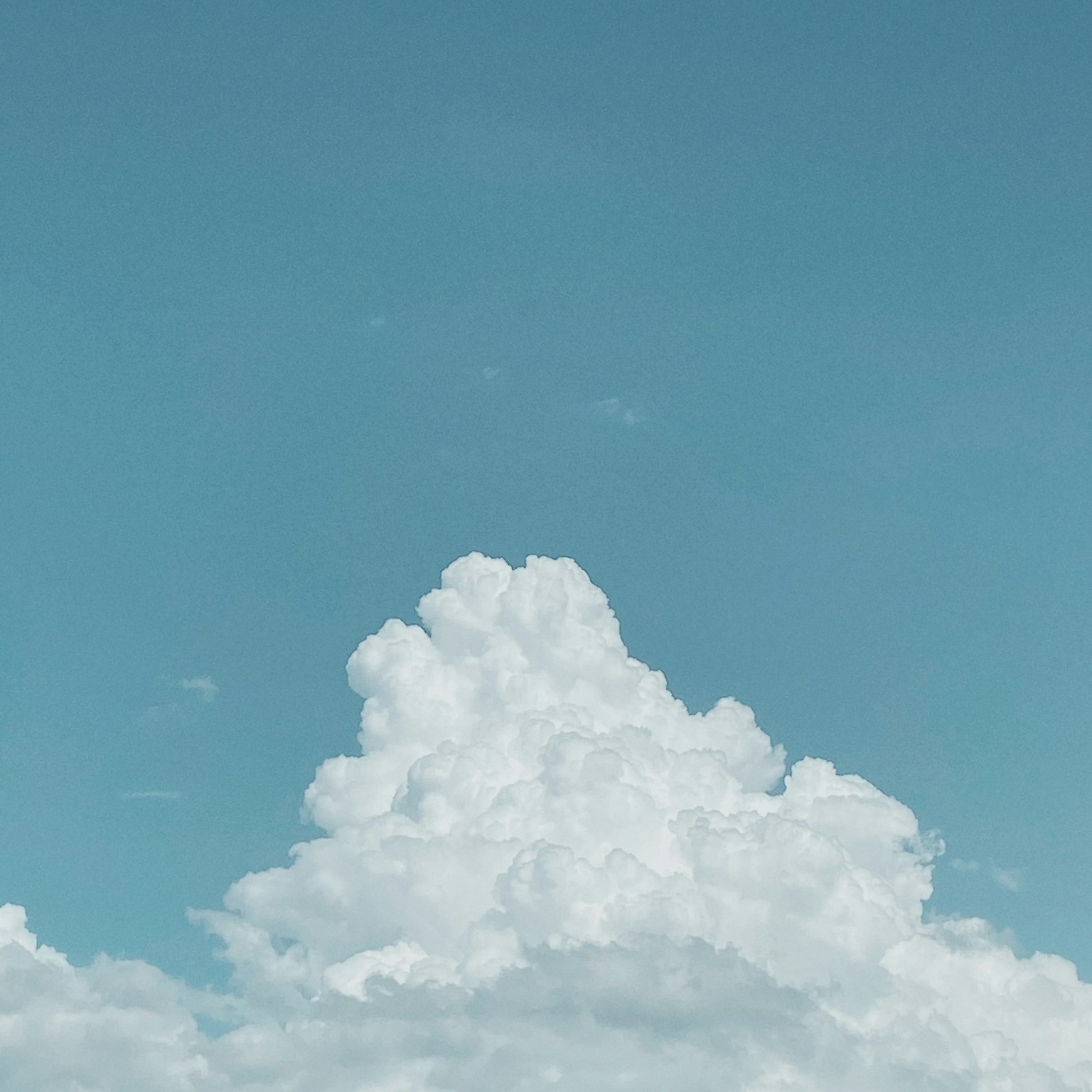 Fluffy white clouds against a clear blue sky
