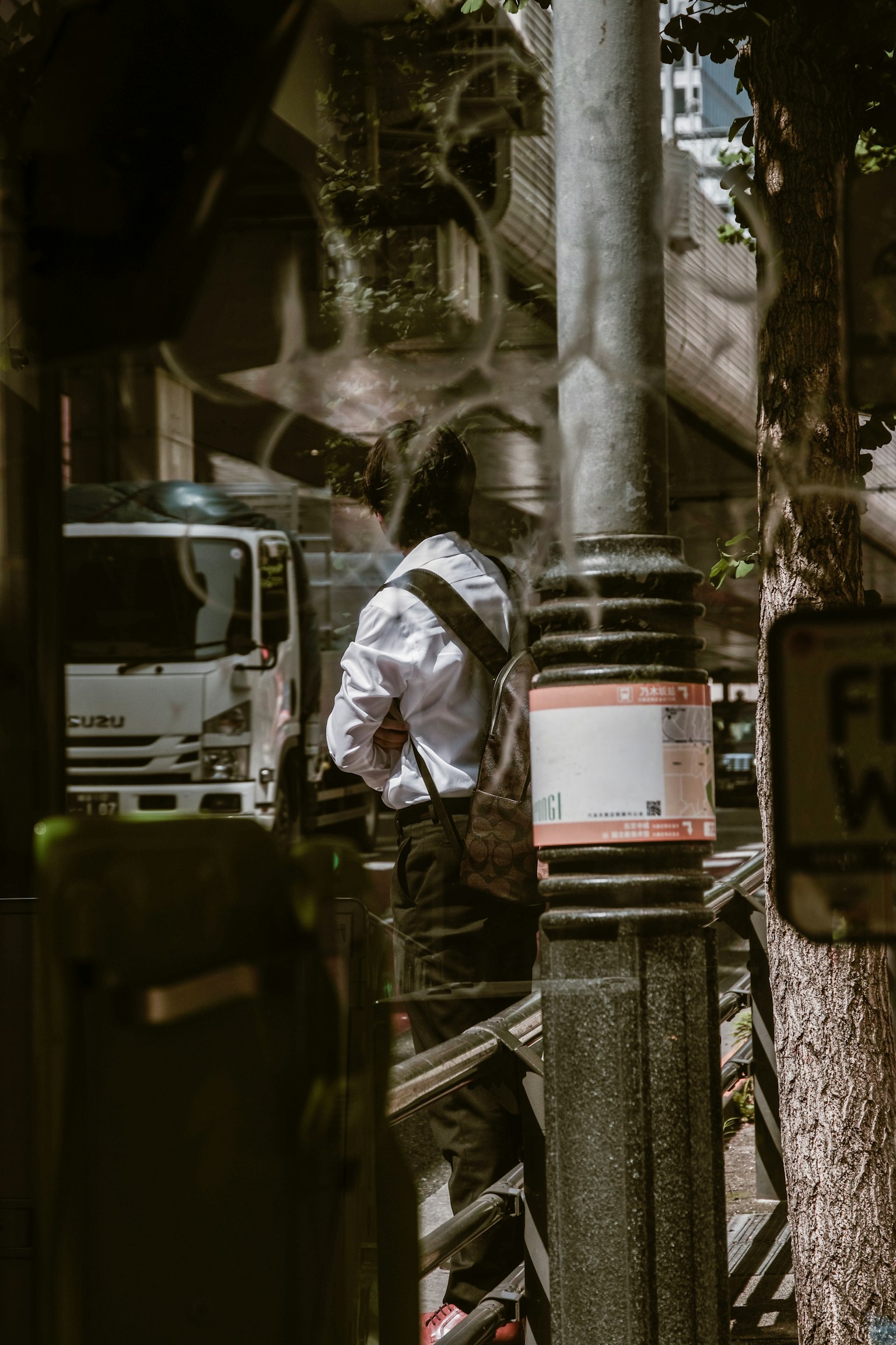 Un homme debout à un coin de rue de la ville avec un reflet de camion