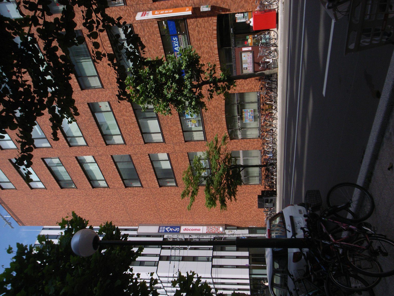Vista di strada con un edificio in mattoni rossi e biciclette parcheggiate