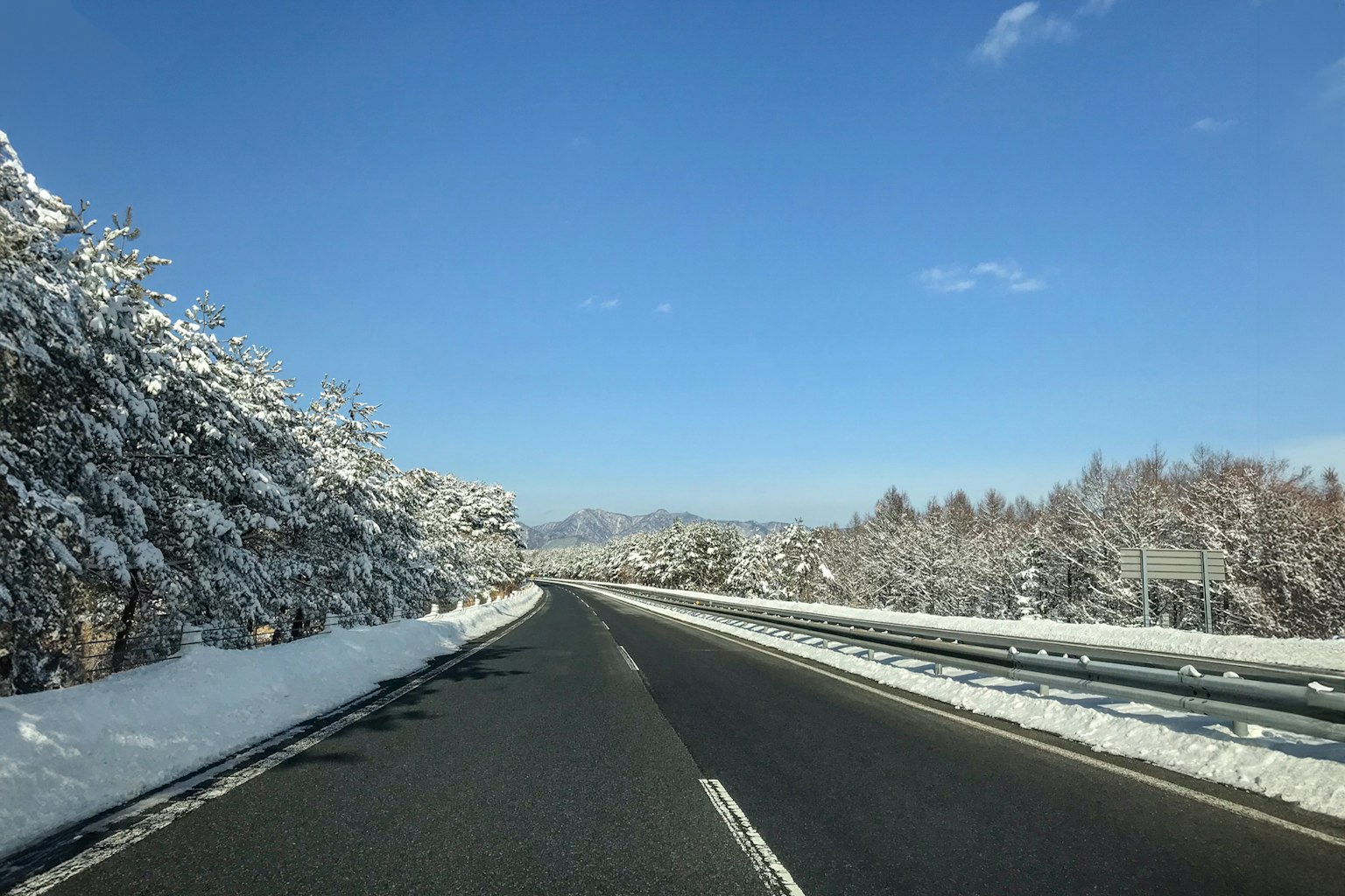 Strada coperta di neve con cielo blu