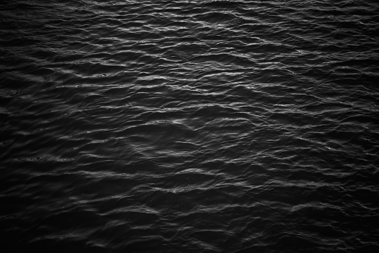 Image de la surface de l'eau sombre avec des ondulations visibles