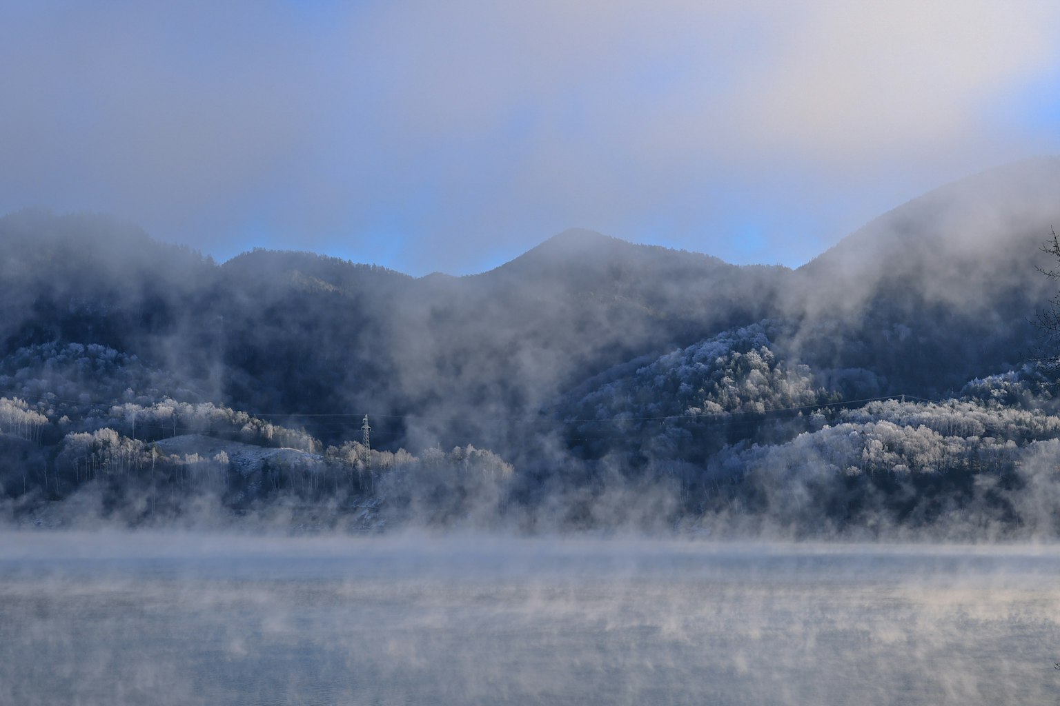 被雾气笼罩的雪山与寒冷的湖面