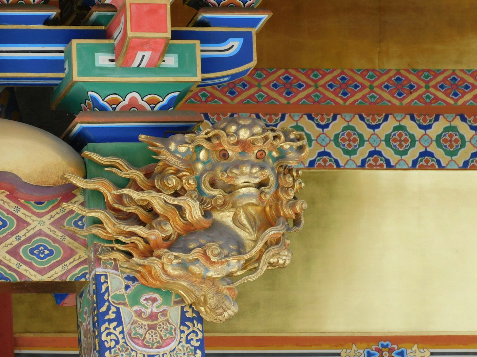 Traditional architectural detail featuring a golden lion sculpture with colorful decorations
