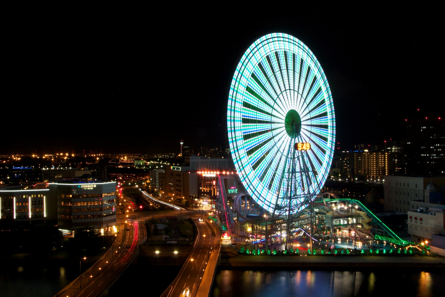 Vue nocturne d'une grande roue illuminée de lumières vertes