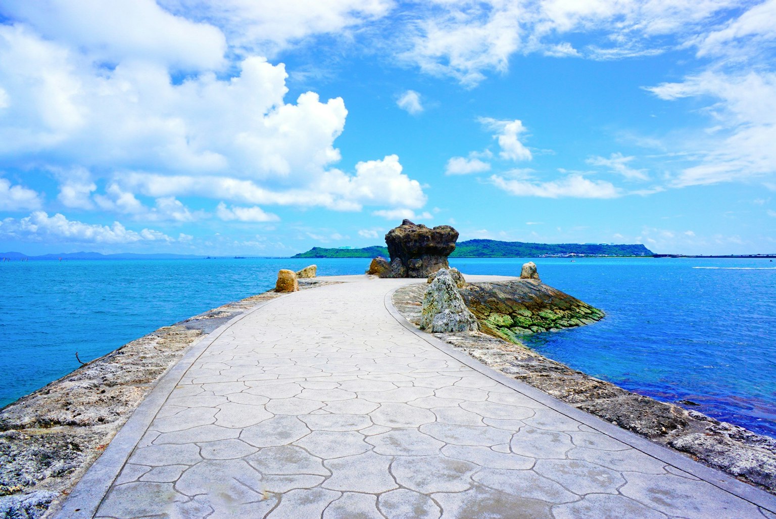 Jalan indah membentang di atas lautan biru dengan formasi batu