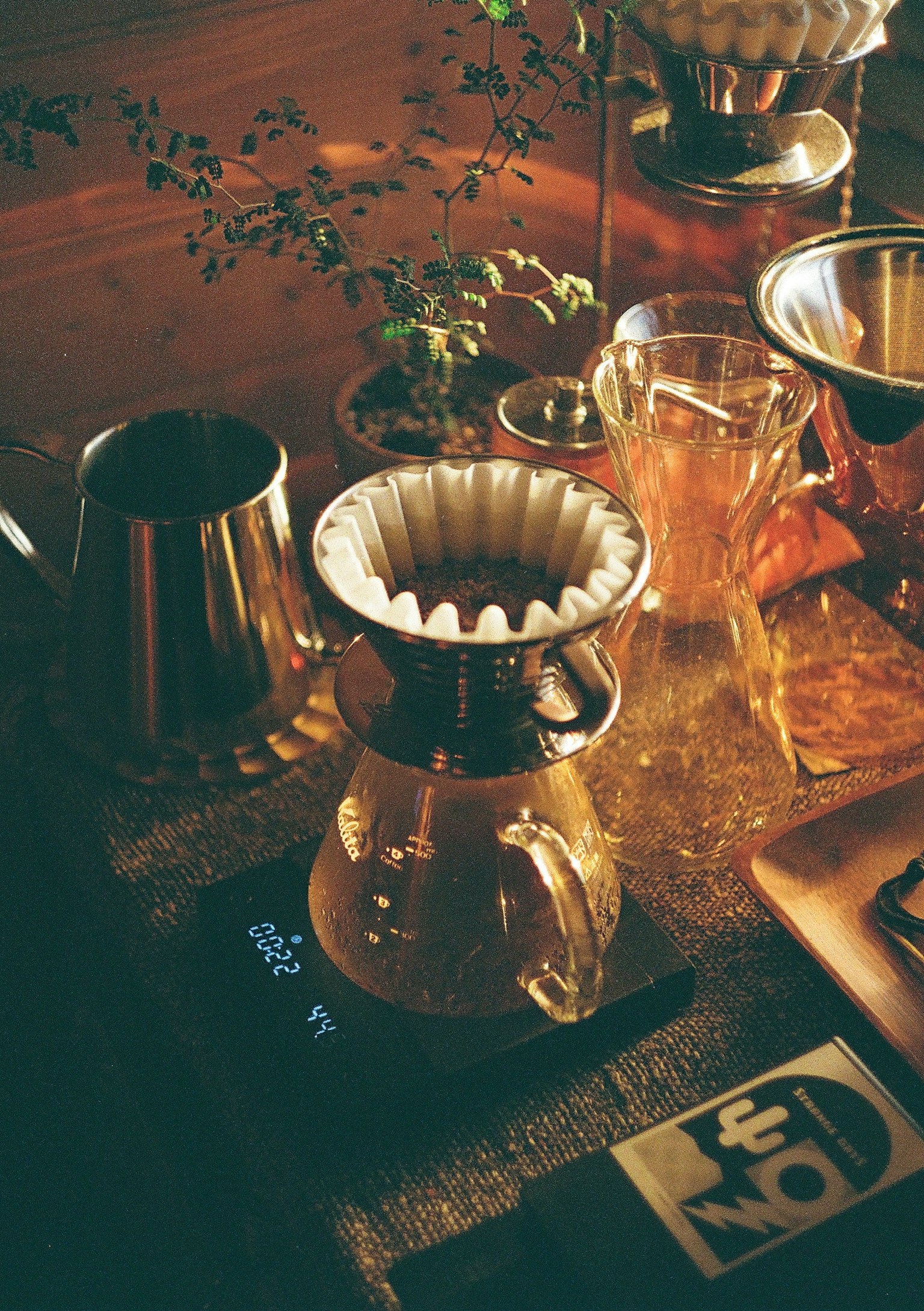 A beautiful coffee brewing setup featuring a dripper and various tools in warm lighting