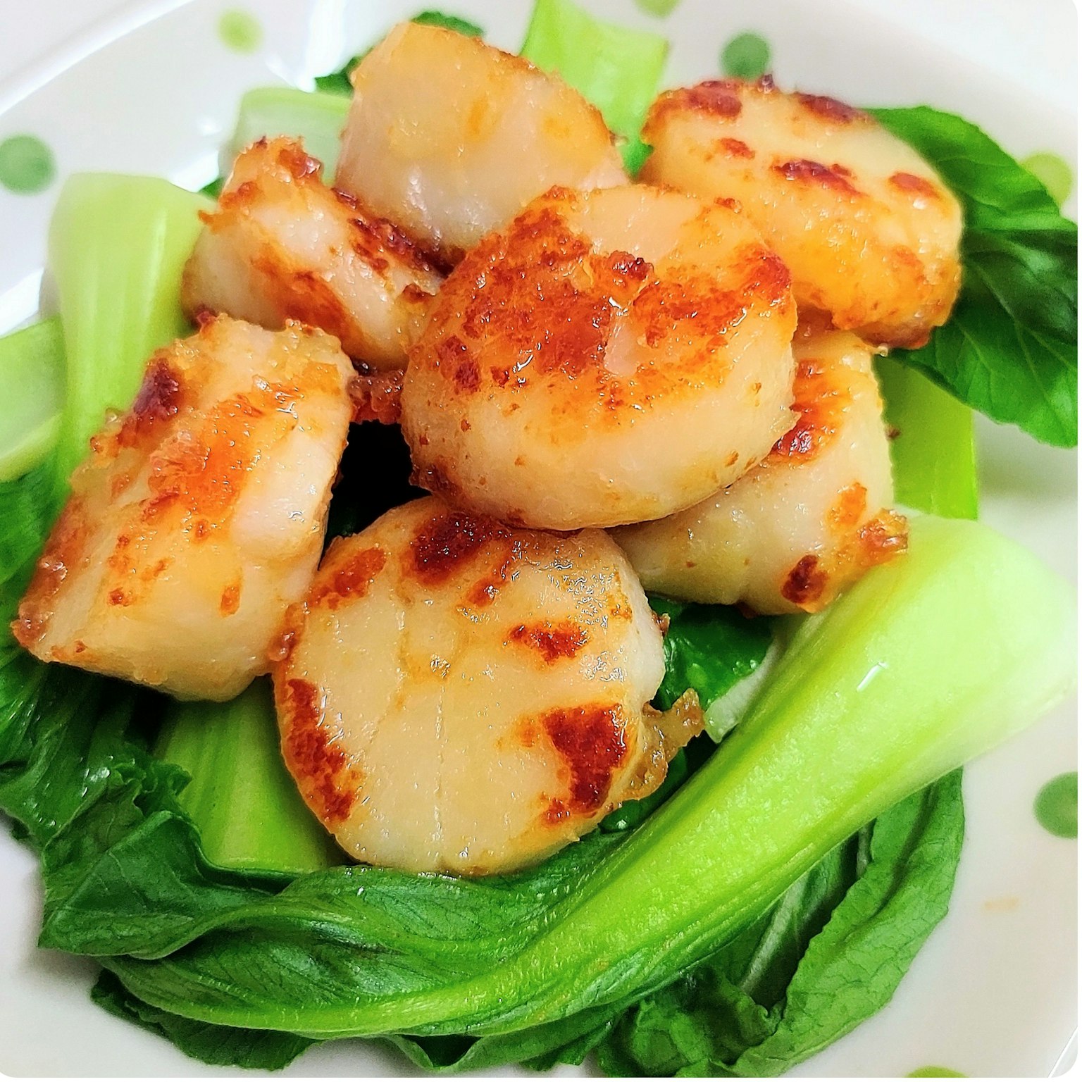 Scallop panggang disajikan di atas bok choy