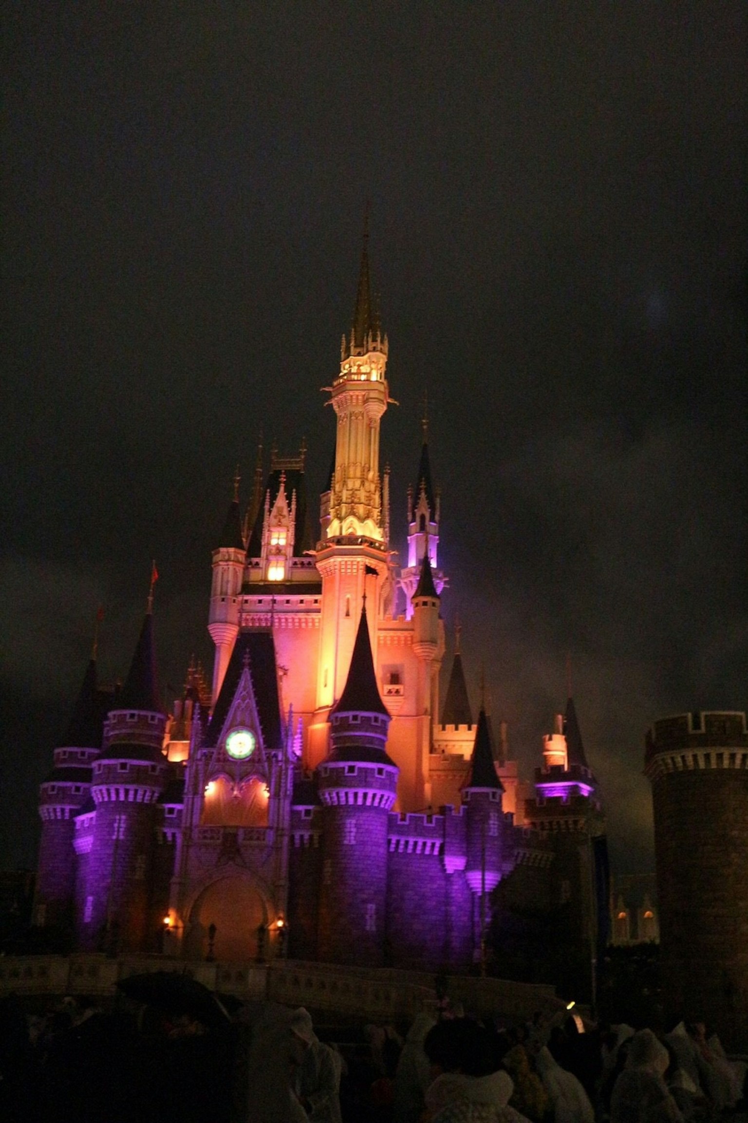 Castillo iluminado por la noche con luces moradas