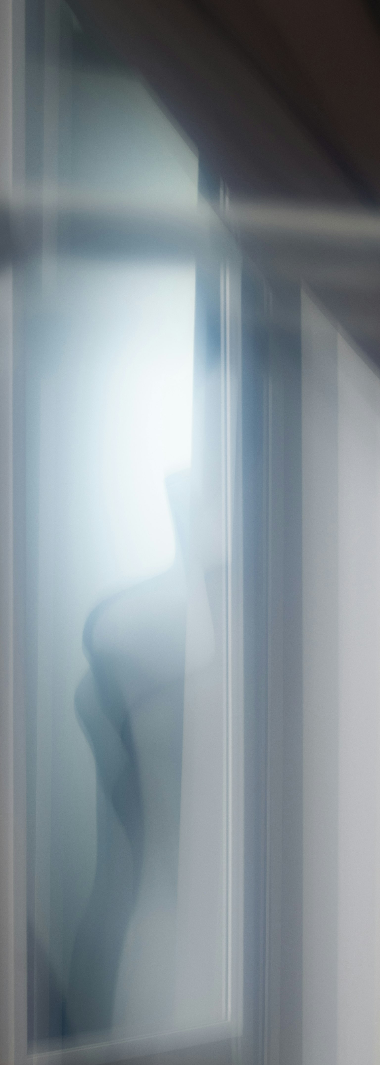 Vage Silhouette einer Person durch ein Fenster gesehen