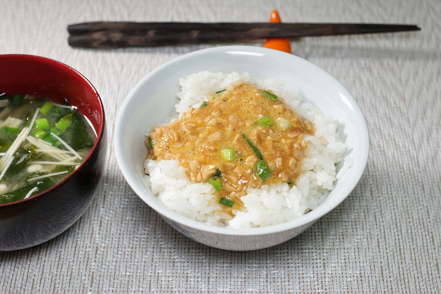 Bol de riz garni de sauce et un bol de soupe miso à côté