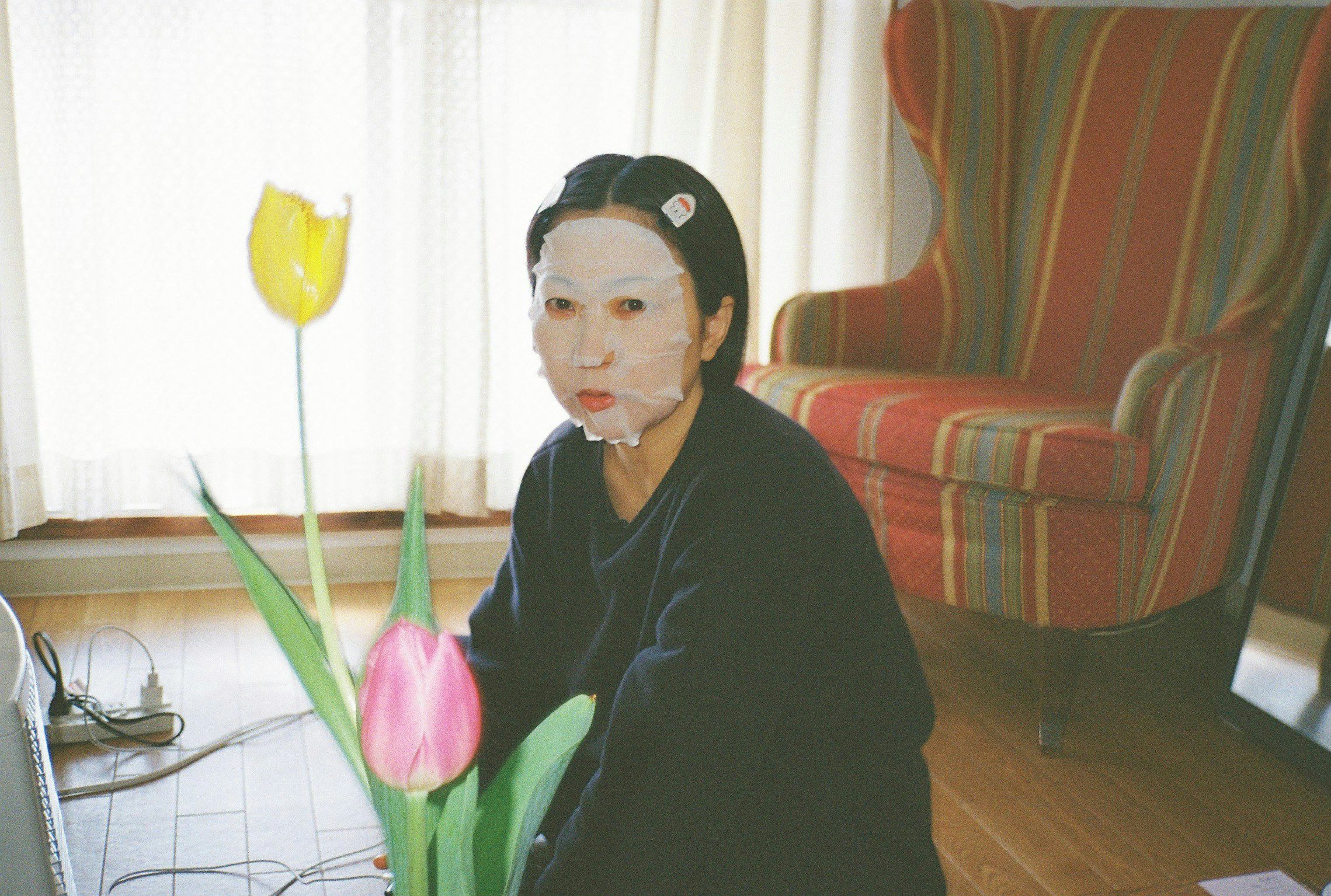 花のある室内で微笑む女性