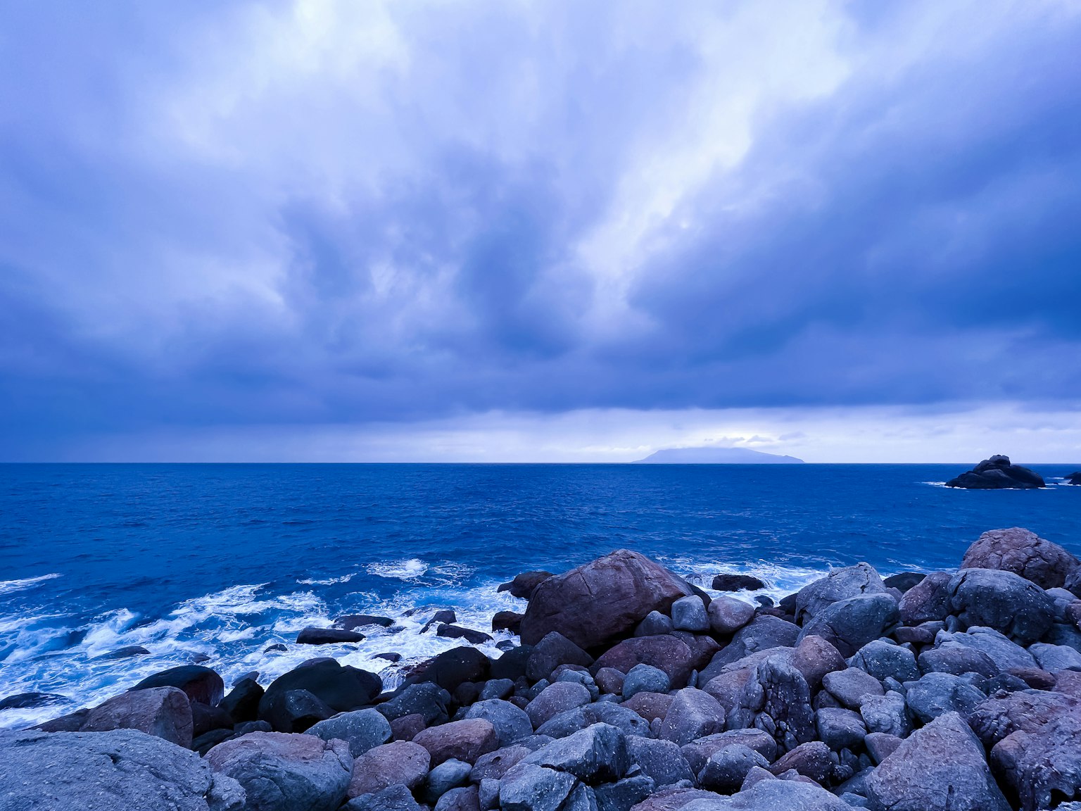 Vue scénique d'un océan bleu avec une côte rocheuse cieux nuageux
