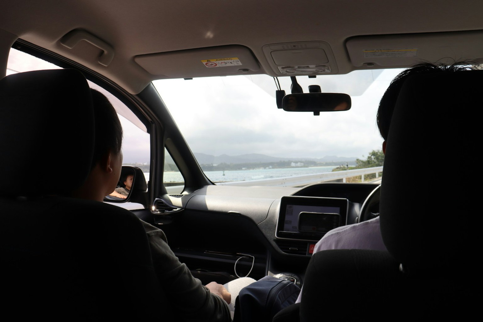 Due persone in auto che guardano il mare
