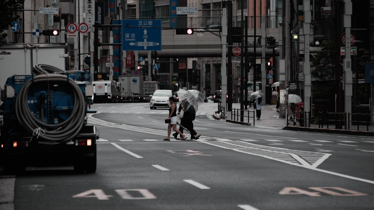 Un parent et un enfant traversant la rue avec un décor urbain comprenant des panneaux de circulation et des véhicules