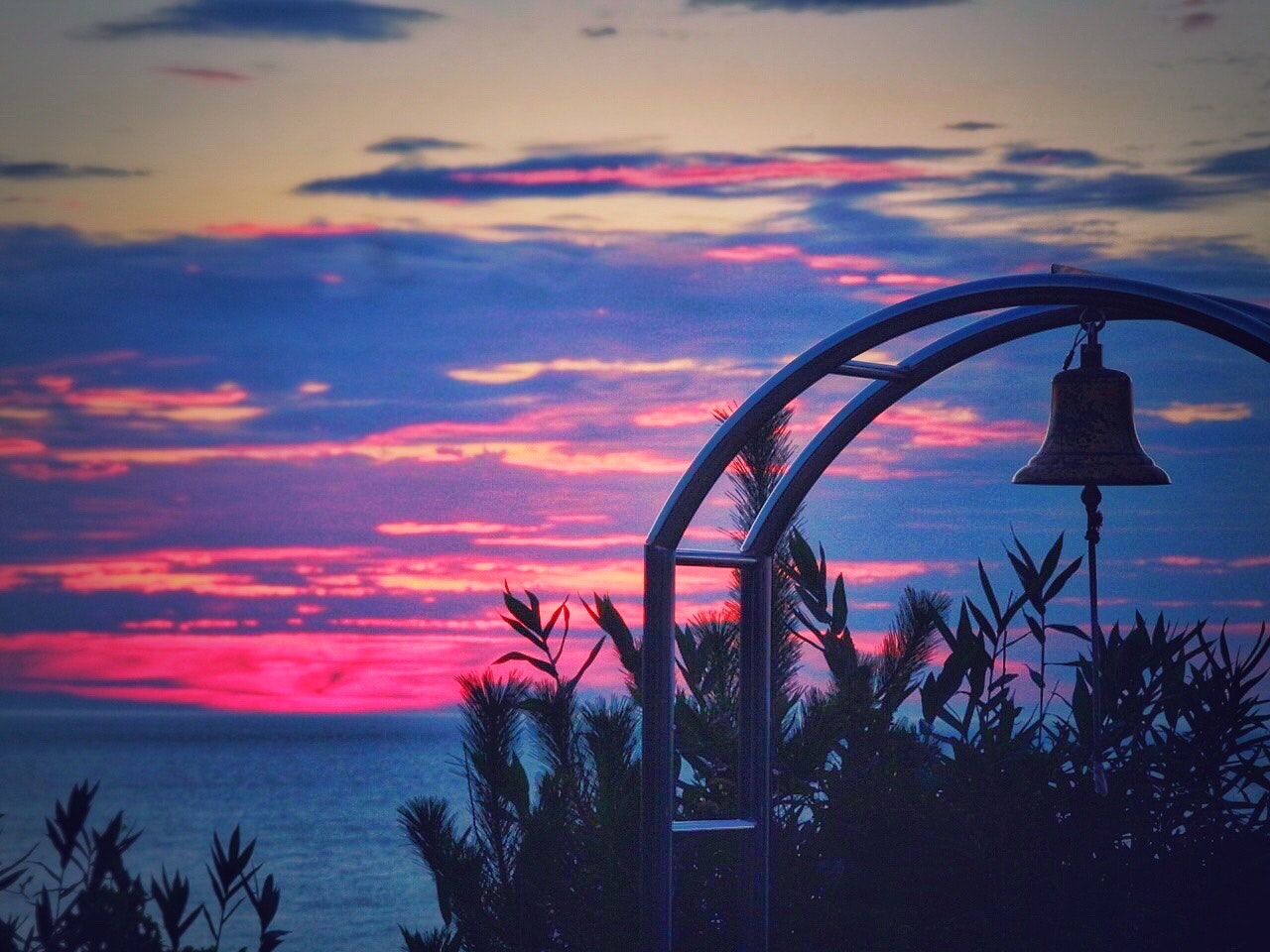 海辺の夕焼け空に鳴る鐘と竹のある景色