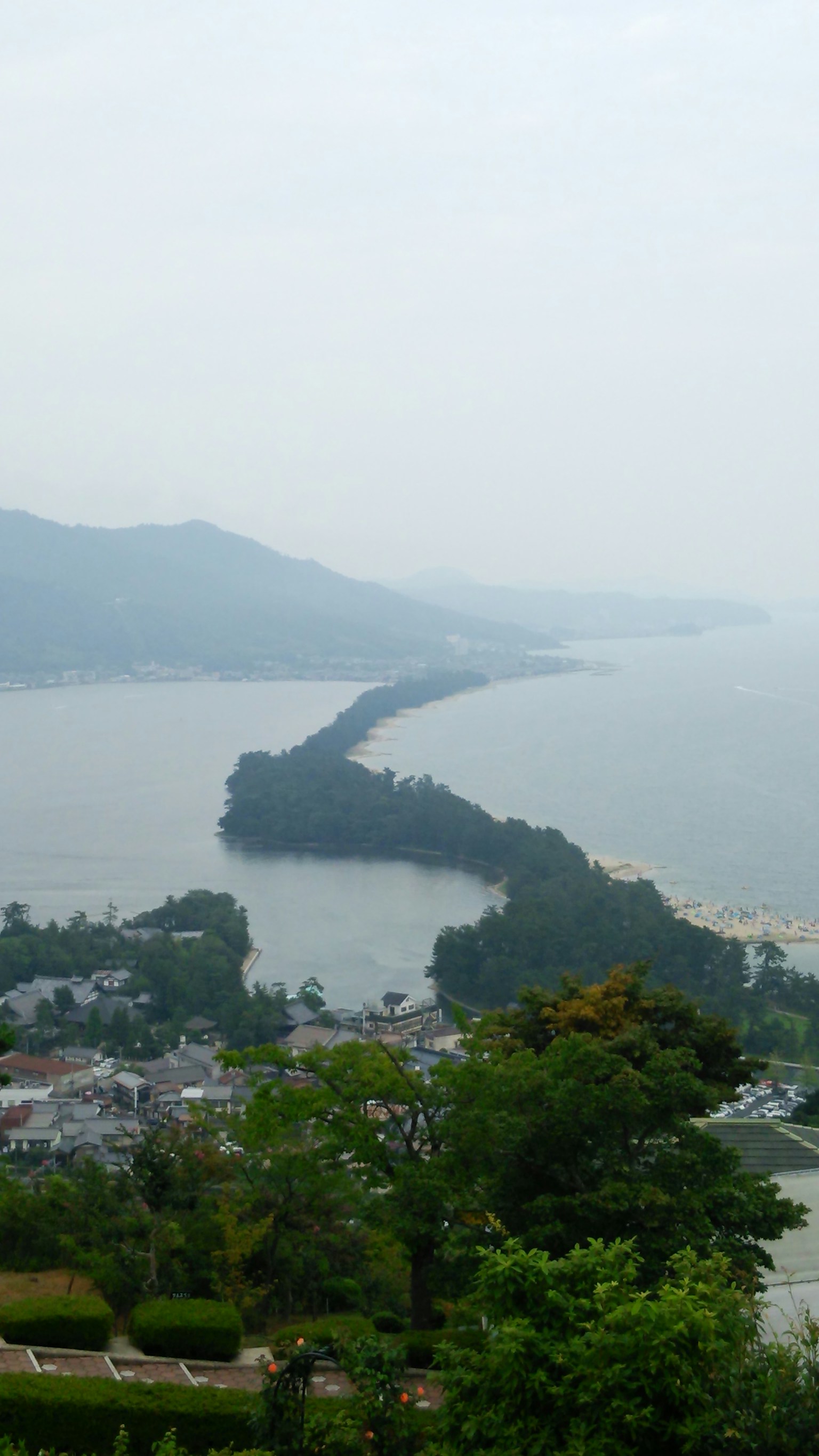 Scenic view of a winding path along the coastline with greenery