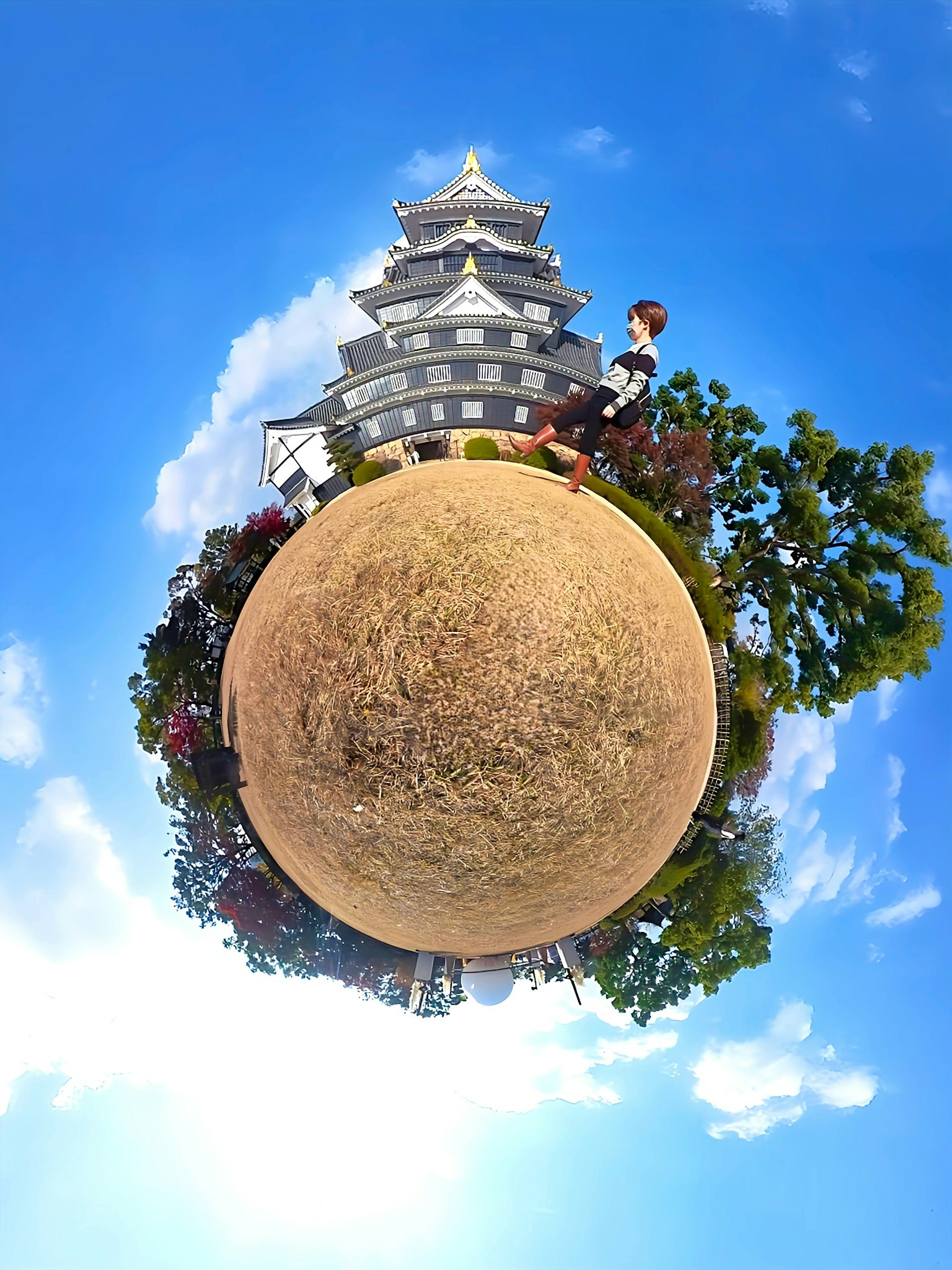 日本城堡的全景，周圍環繞著綠色樹木和藍天