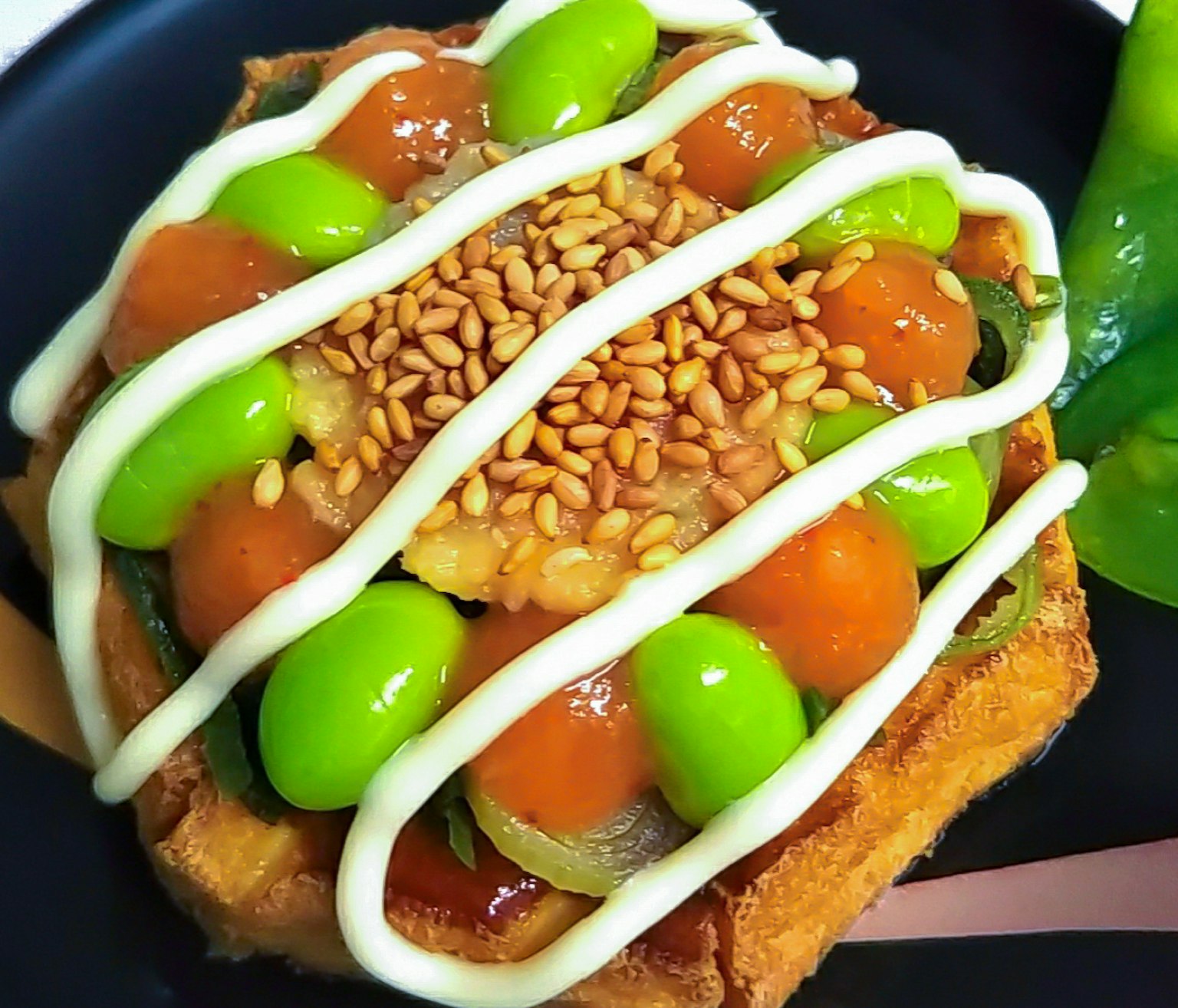 Toast garni de haricots verts et de noix, arrosé de mayonnaise et de graines de sésame
