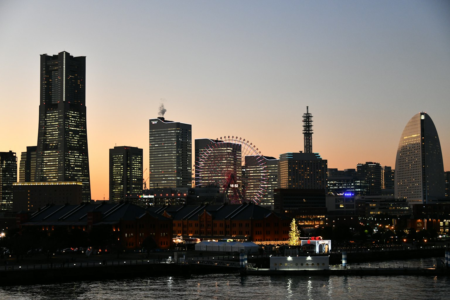 Đường chân trời Yokohama vào lúc hoàng hôn với các tòa nhà và vòng quay