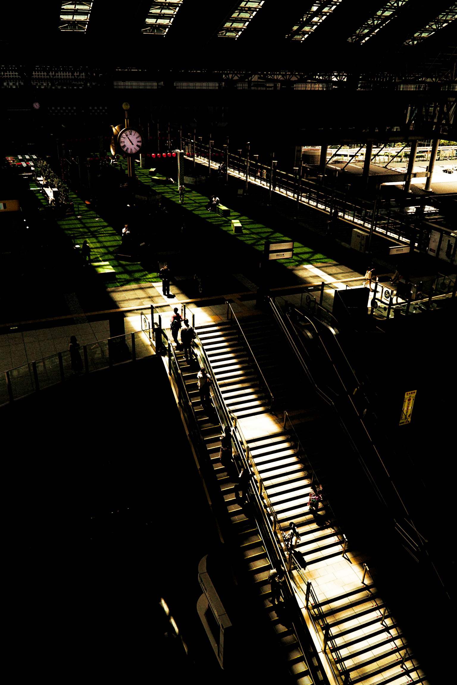 ภายในสถานีรถไฟสมัยใหม่ที่มีบันไดสว่างและพื้นหลังมืด