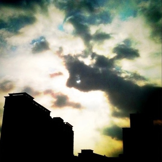 夕暮れの空に浮かぶ雲と街並みのシルエット