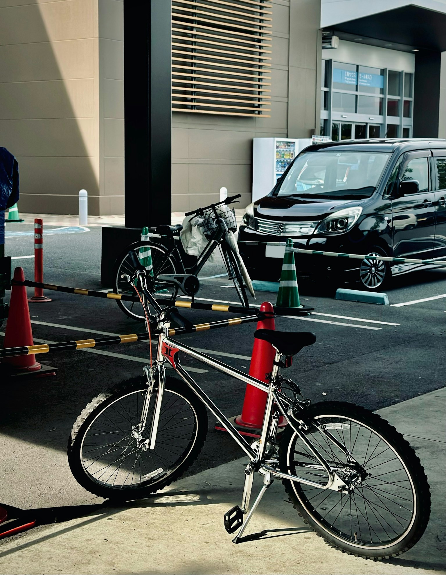Bicicleta y coche en un aparcamiento La bicicleta es plateada y roja