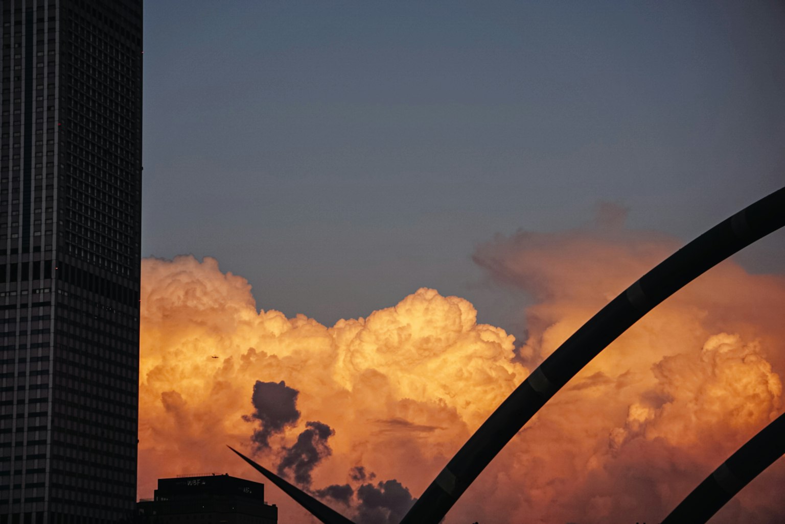 Silhouette d'un bâtiment contre des nuages de coucher de soleil vibrants