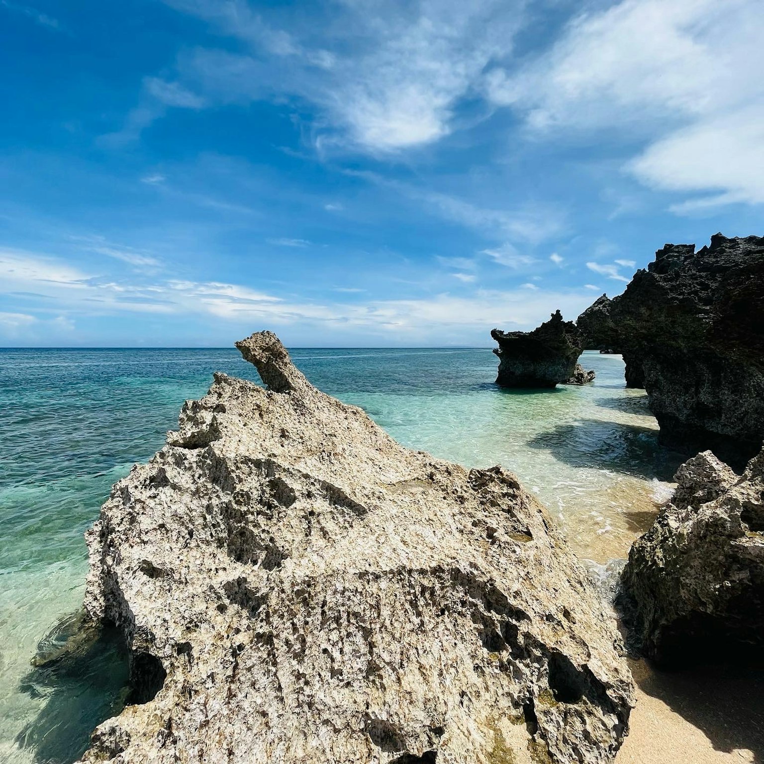 海灘場景，特徵為藍色海洋和獨特的岩石形成