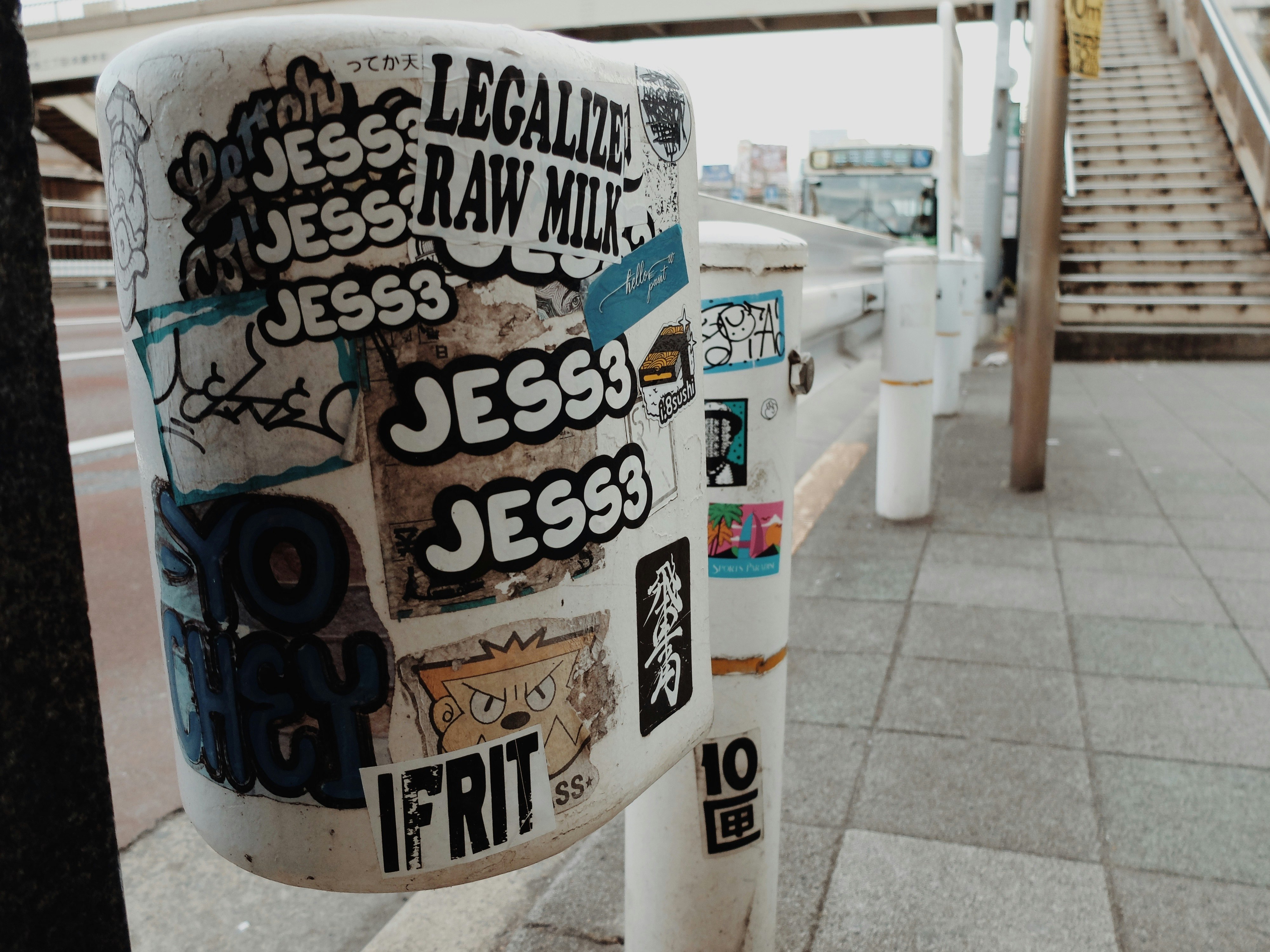 落書きステッカーが貼られた紙コップの並ぶ屋外通路