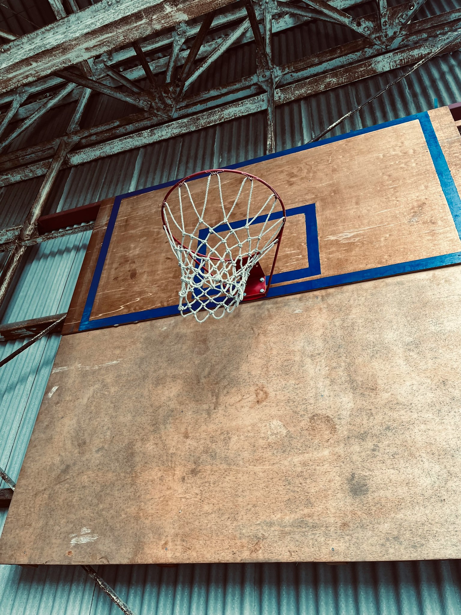 Photo of a basketball hoop mounted on a wooden backboard