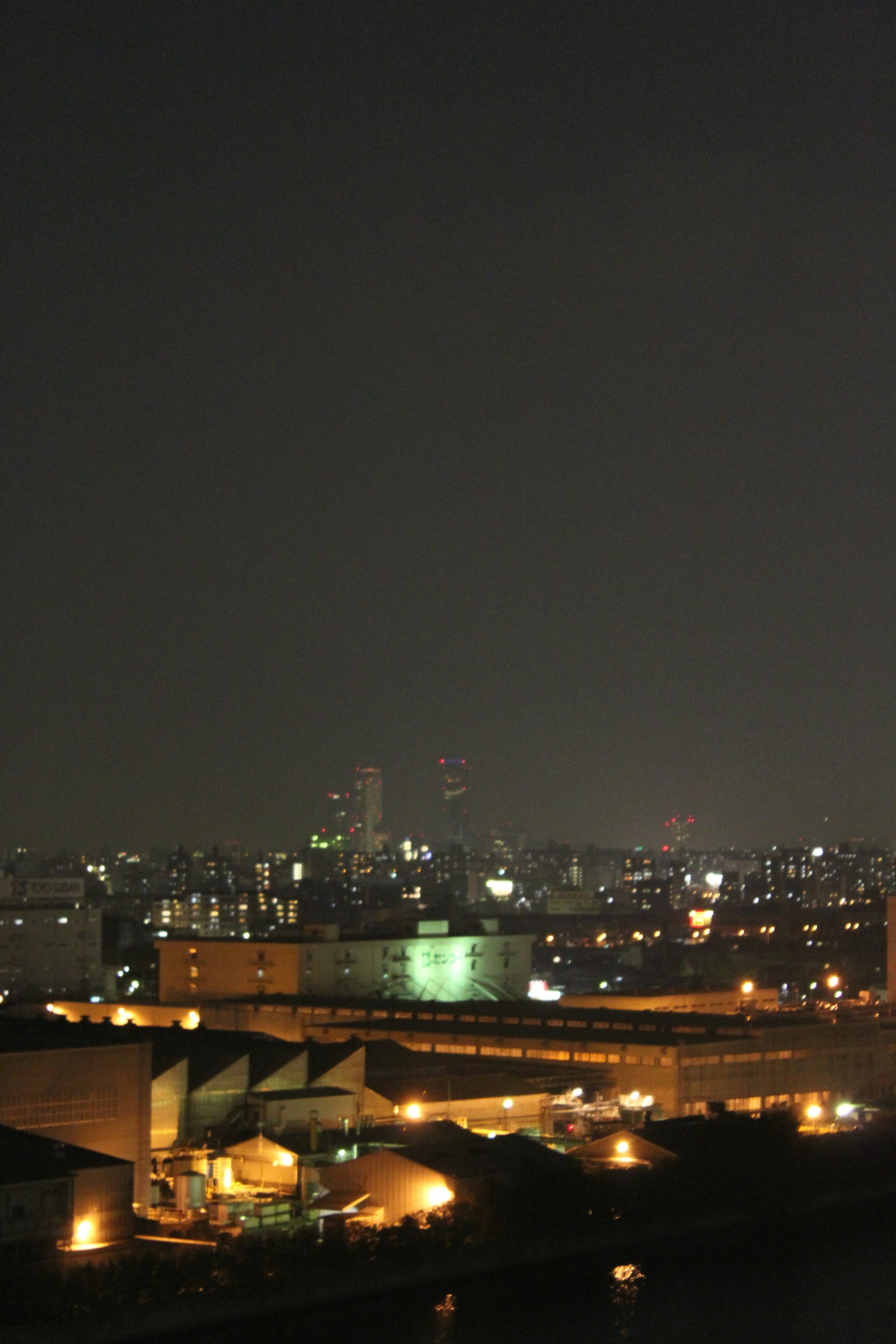 Paesaggio urbano notturno con edifici illuminati e grattacieli in lontananza
